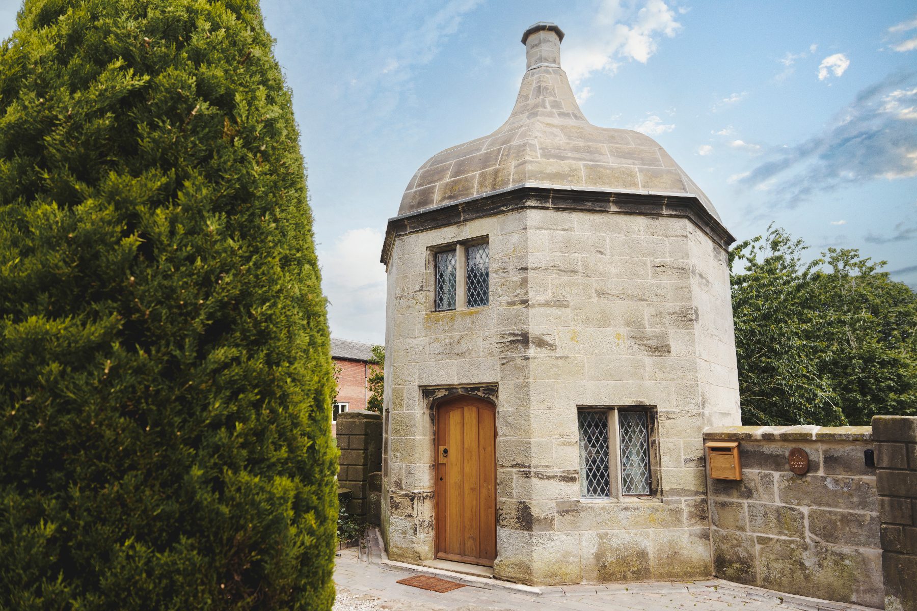 Bottle Lodge, an octagonal sandstone gate lodge with a distinctive curved roof, in Tixall.